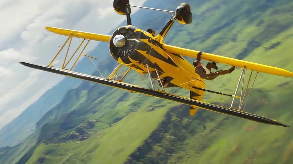 Tom Cruise hanging by the wing of a plane