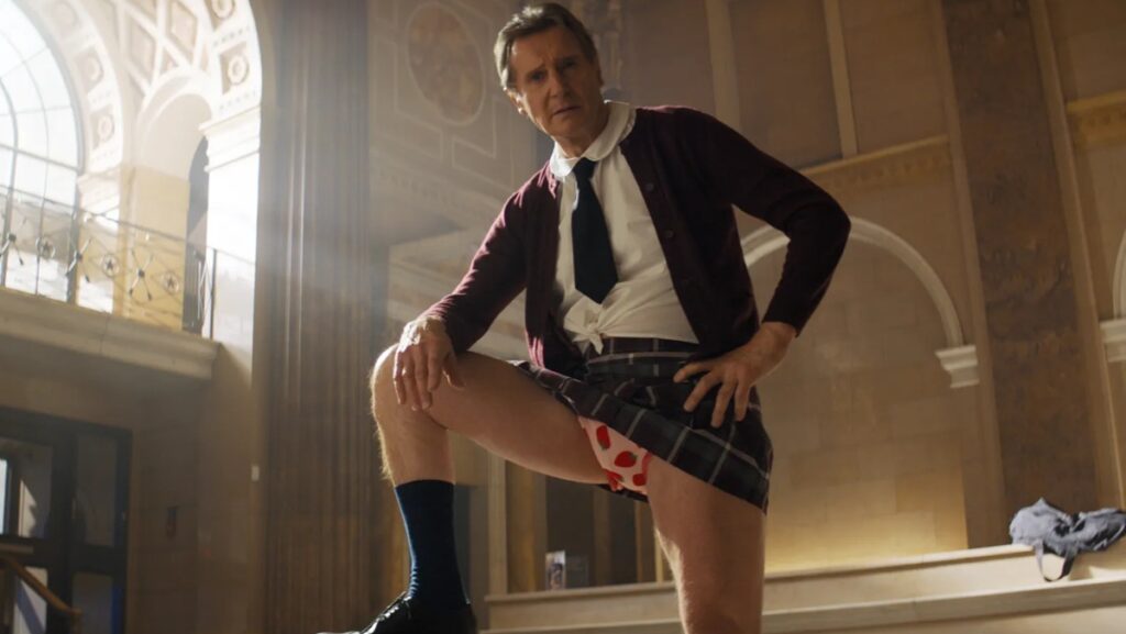 Liam Neeson introduces himself as “Frank Drebin, Jr, Police Squad,” in a scene from ‘The Naked Gun’
