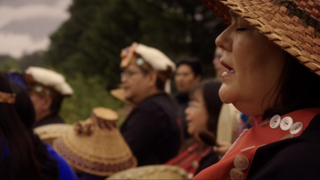 Nuskmata sings during a ceremony at the sputc pole on the bank of the Bella Coola.