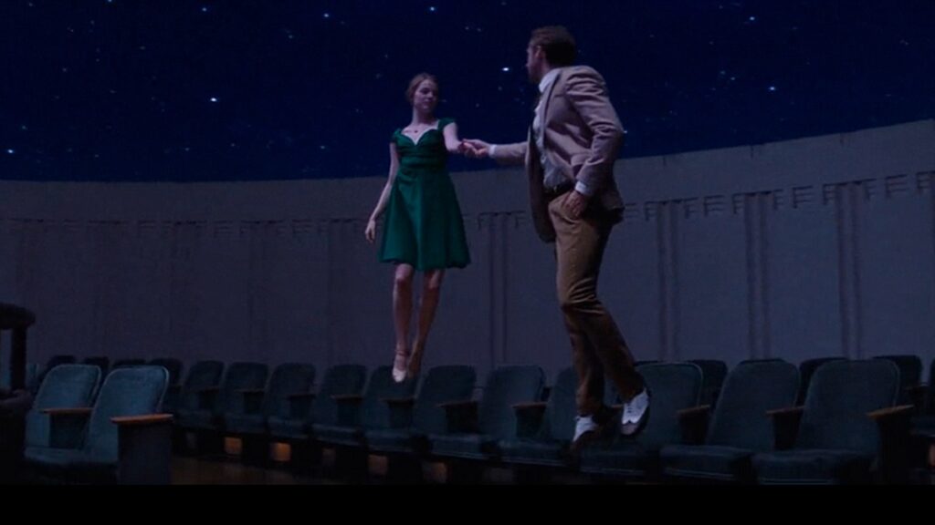 Mia and Sebastian float in an observatory.