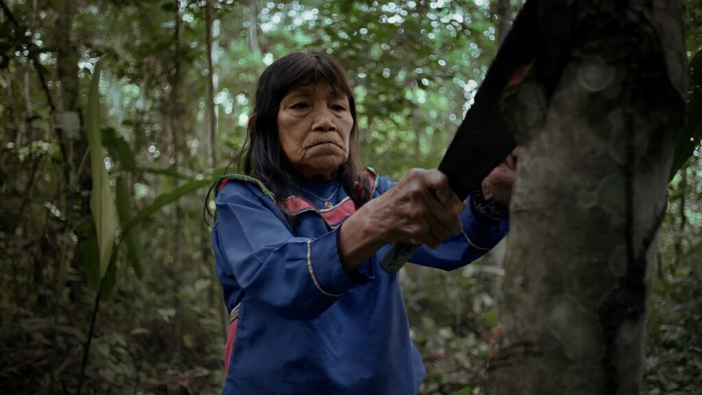 Sara Flores working on a tree bark for her kené.
